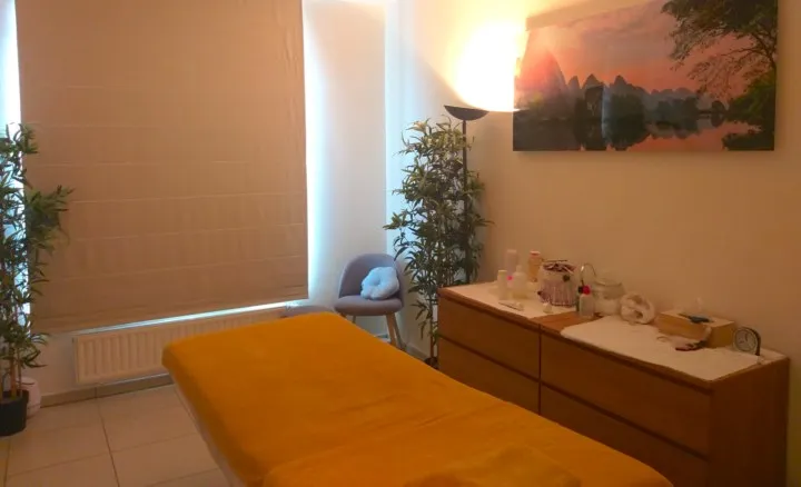 La cabine de soins de l'institut à Genval, avec sa table de massage, ses plantes vertes et sa lumière tamisée